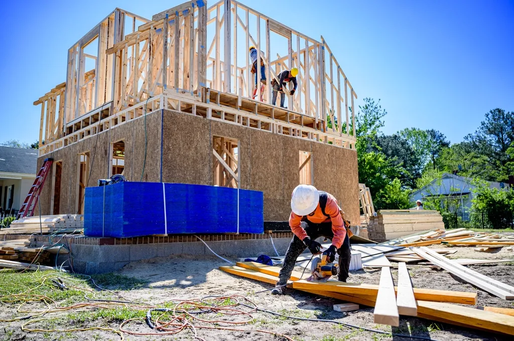 New home framing with crew members working on the second floor